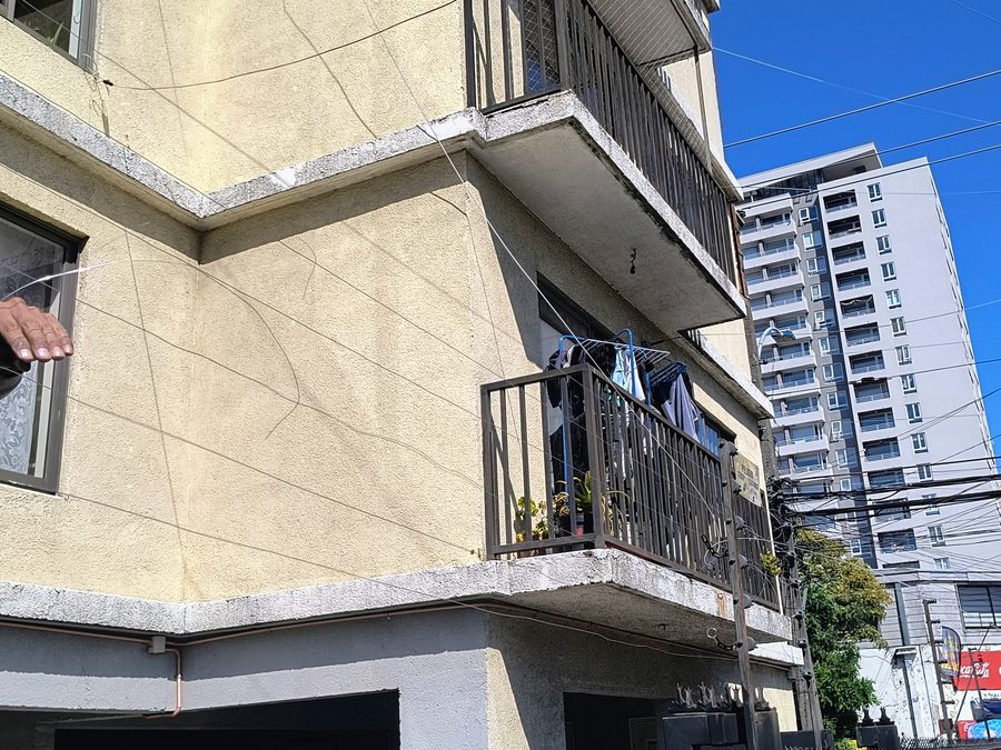 Técnico instalando cerco eléctrico perimetral en la fachada de un edificio