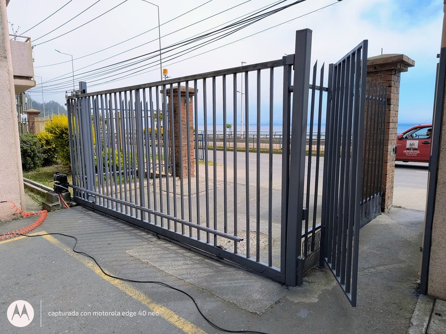 Portón corredizo automatizado instalado en un acceso frente al mar